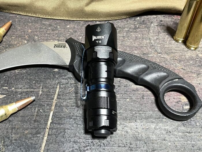 Wuben T4 Review: The Newest Tactical Flashlight in Wubens Arsenal 2 Wuben T4 tactical flashlight resting on a cold steel tiger claw